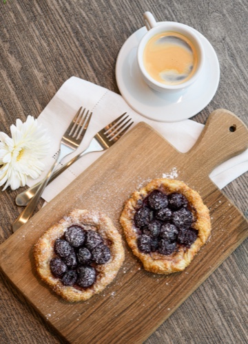 Blackbery Tart and Coffee with two forks and a flower